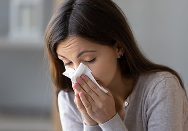Frau putzt sich die Nase Zink kann Allergien beeinflusse